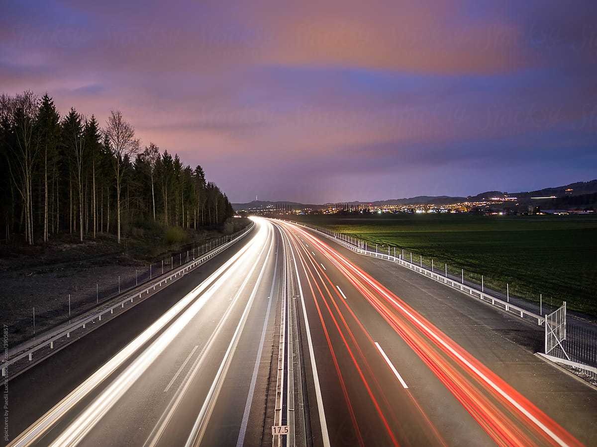 Header mit Motiv Straße umgeben von Wald und Stadtbild im Timelapse-Modus.