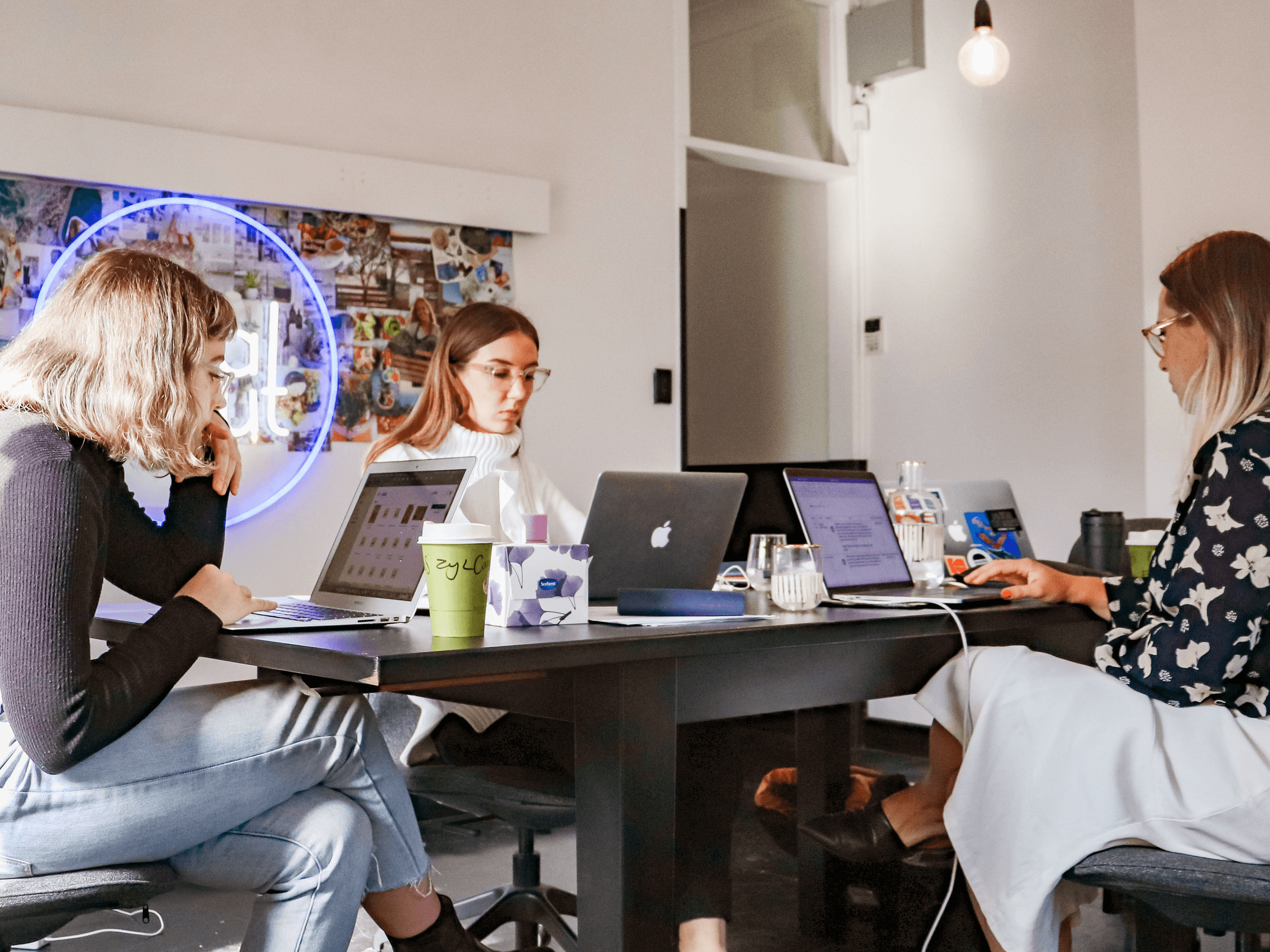 Mehrere Frauen im Office am Schreibtisch arbeiten mit askDANTE Zeiterfassung in Ihrem Startup.