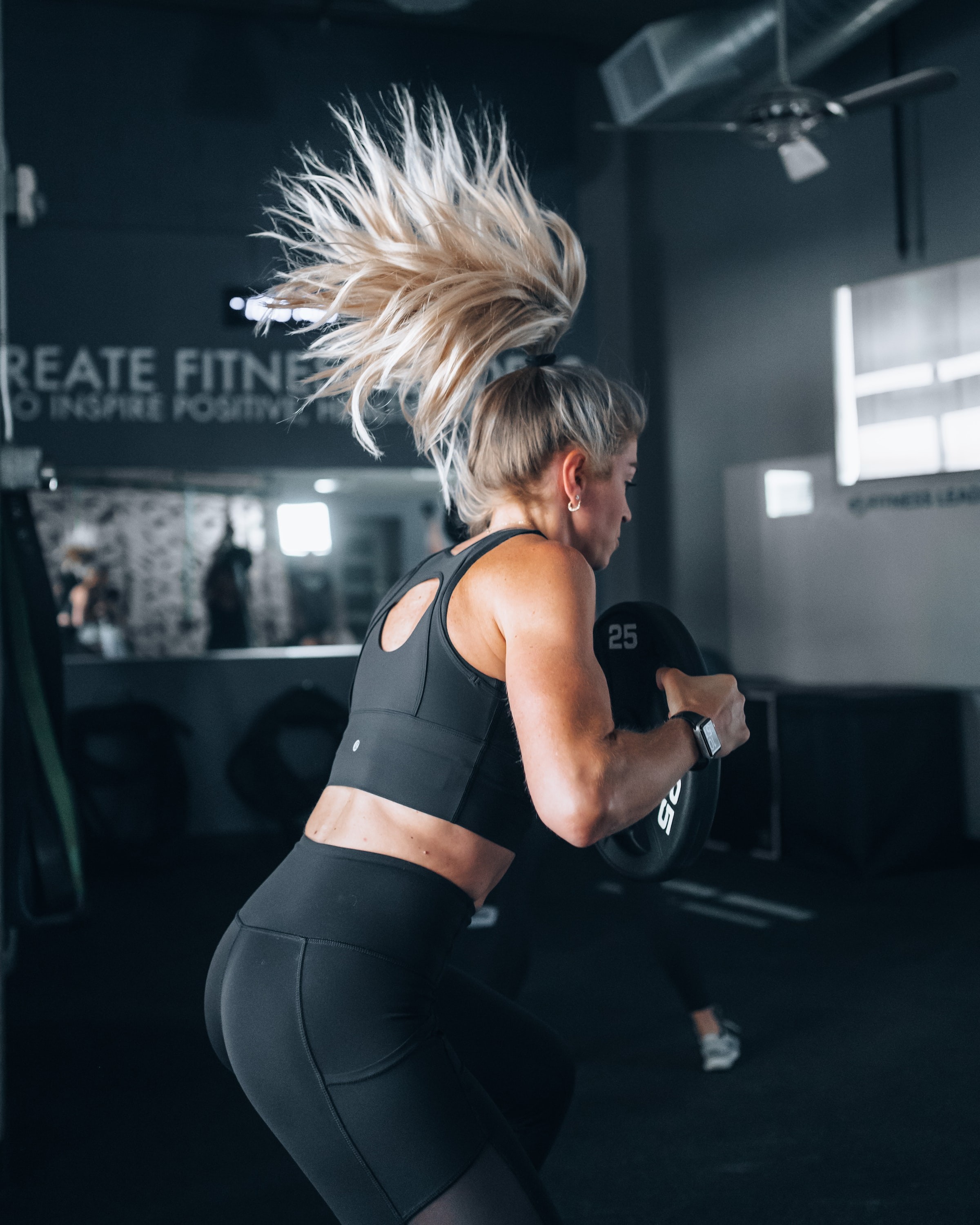 Frau beim Training im Fitnessstudio mit Gewichten.
